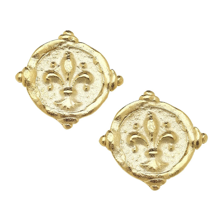 A pair of gold-colored stud earrings featuring a fleur-de-lis design in an intaglio style.