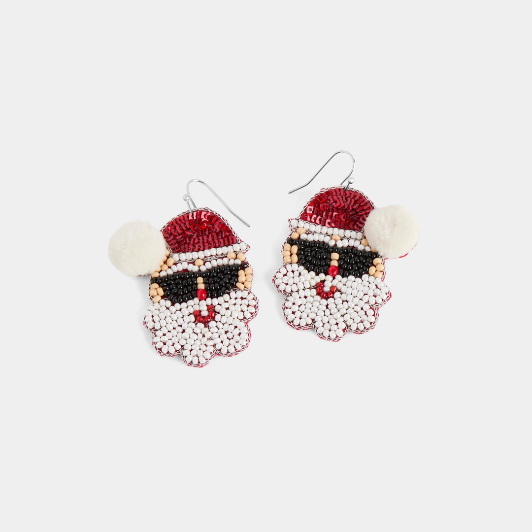 A pair of Santa Claus face beaded drop earrings on silver fishhook wires, featuring red, white, and black seed beads with faux fur pom-poms on a light gray background.