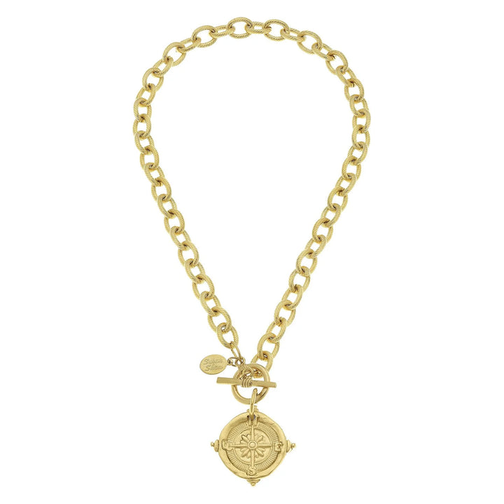 Gold chain necklace with a compass pendant on a white background