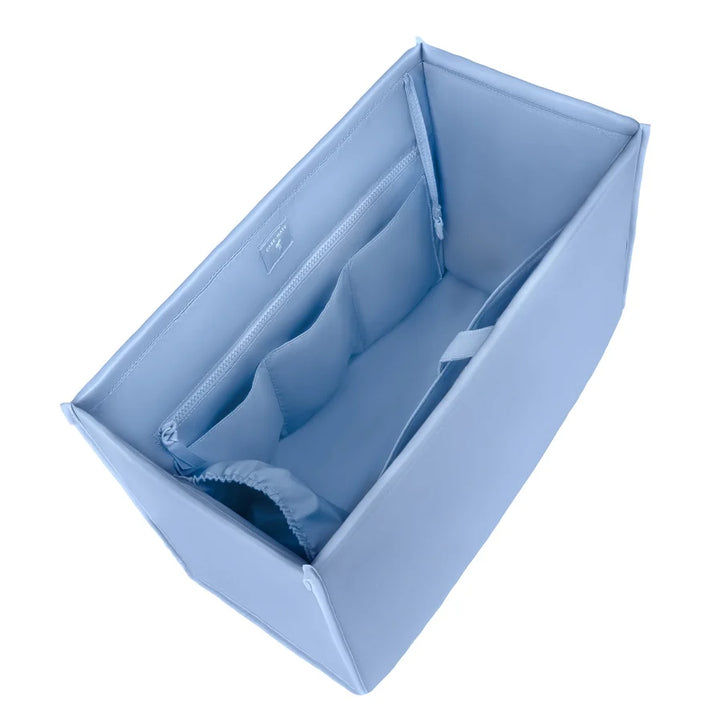 A light blue fabric organizer insert with zippered compartments, shown from an elevated angle on a white background.