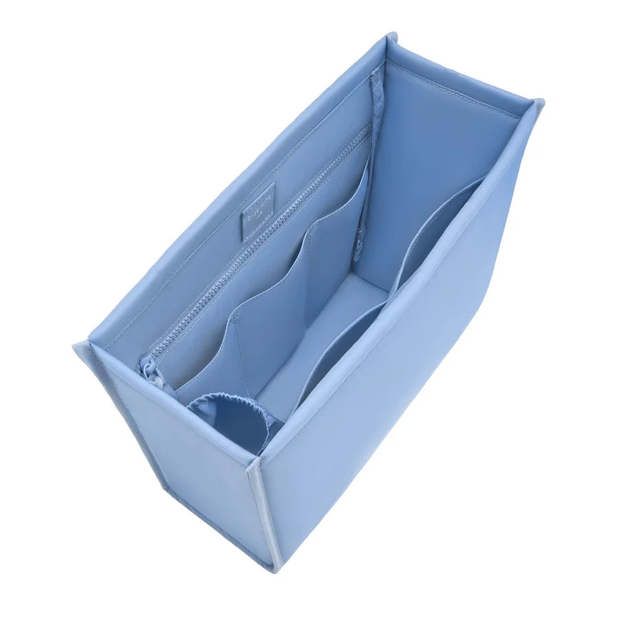 A light blue structured bag filler organizer with multiple interior compartments, shown empty on a solid white background.