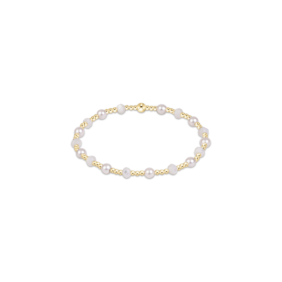 A delicate gold beaded bracelet with white freshwater pearls, featuring a polished gold clasp, shown on a clean white background.