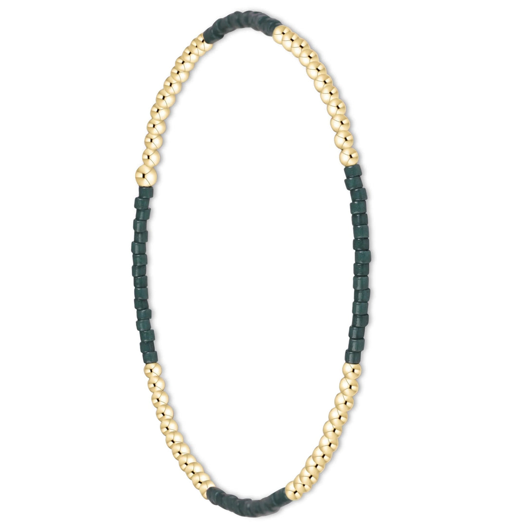 A beaded stretch bracelet featuring alternating sections of polished gold-tone round beads and dark forest green square faceted beads, displayed on a clean white background.