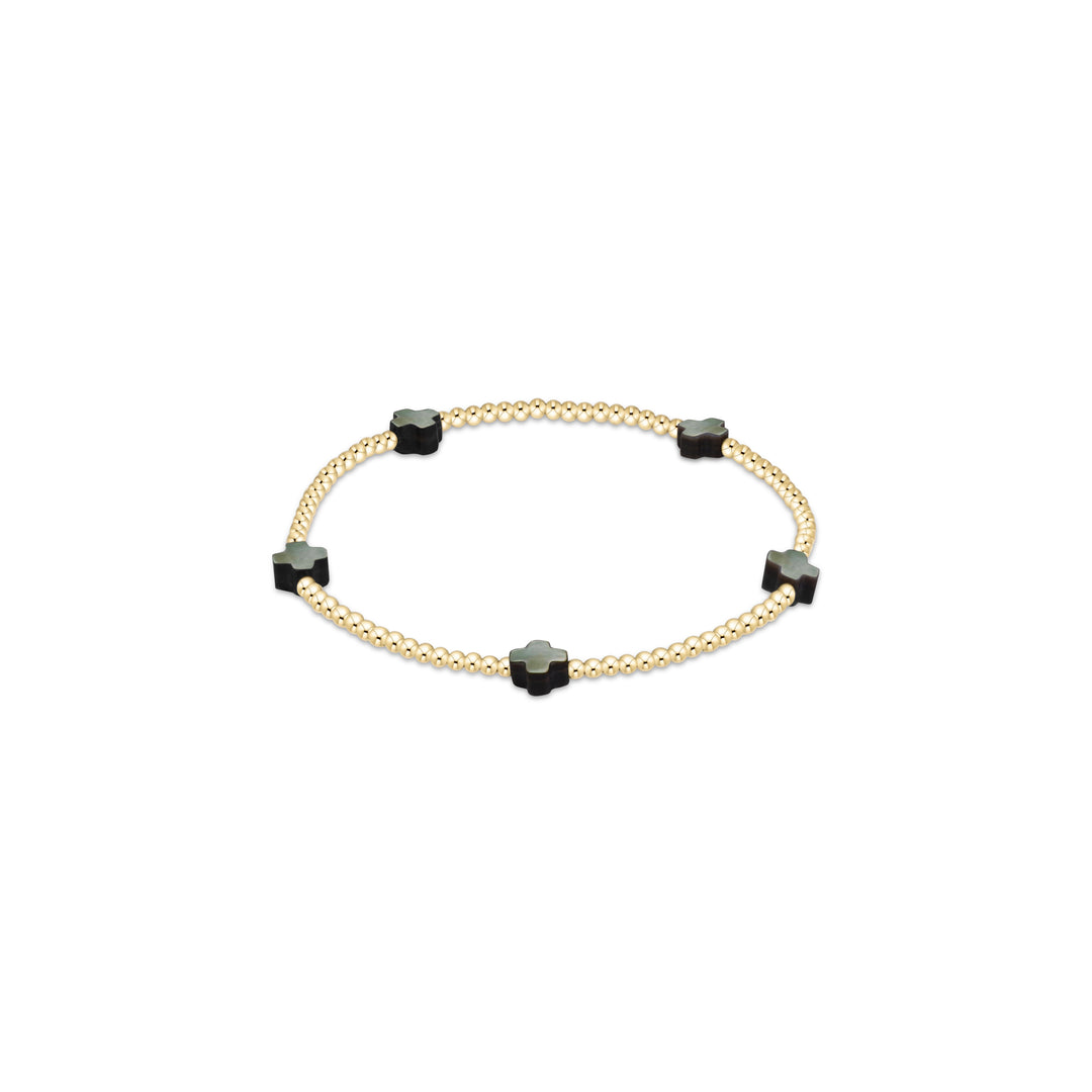 A delicate gold chain bracelet featuring five evenly spaced black square beads with rounded corners, displayed on a clean white background.