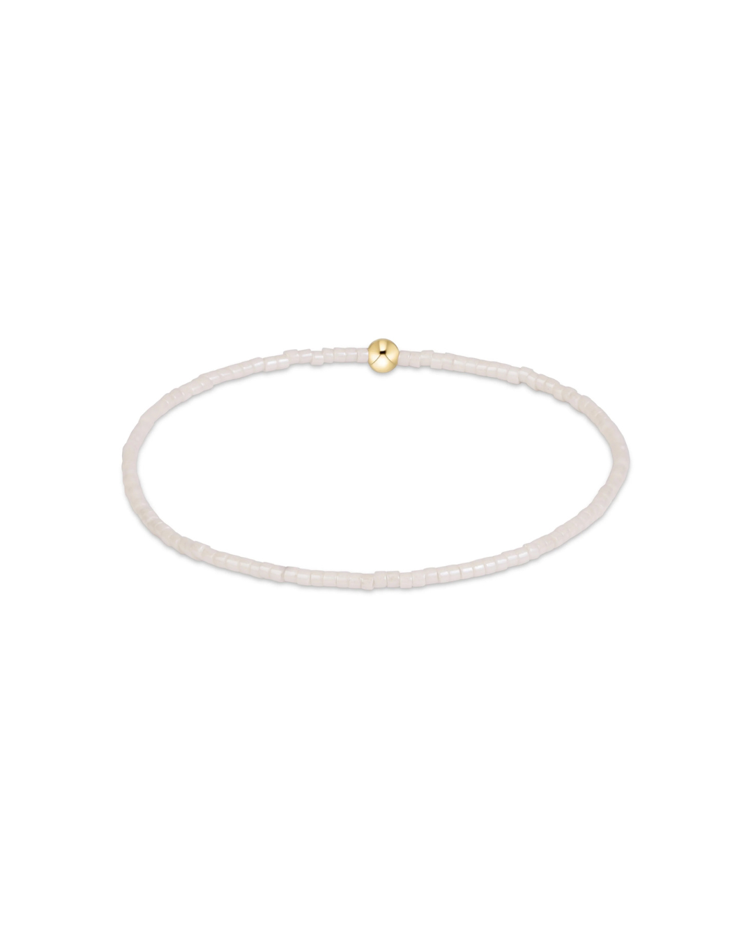 A delicate beaded bracelet in a pale champagne or off-white tone, featuring a single small gold bead accent at the top center, shown on a plain white background.