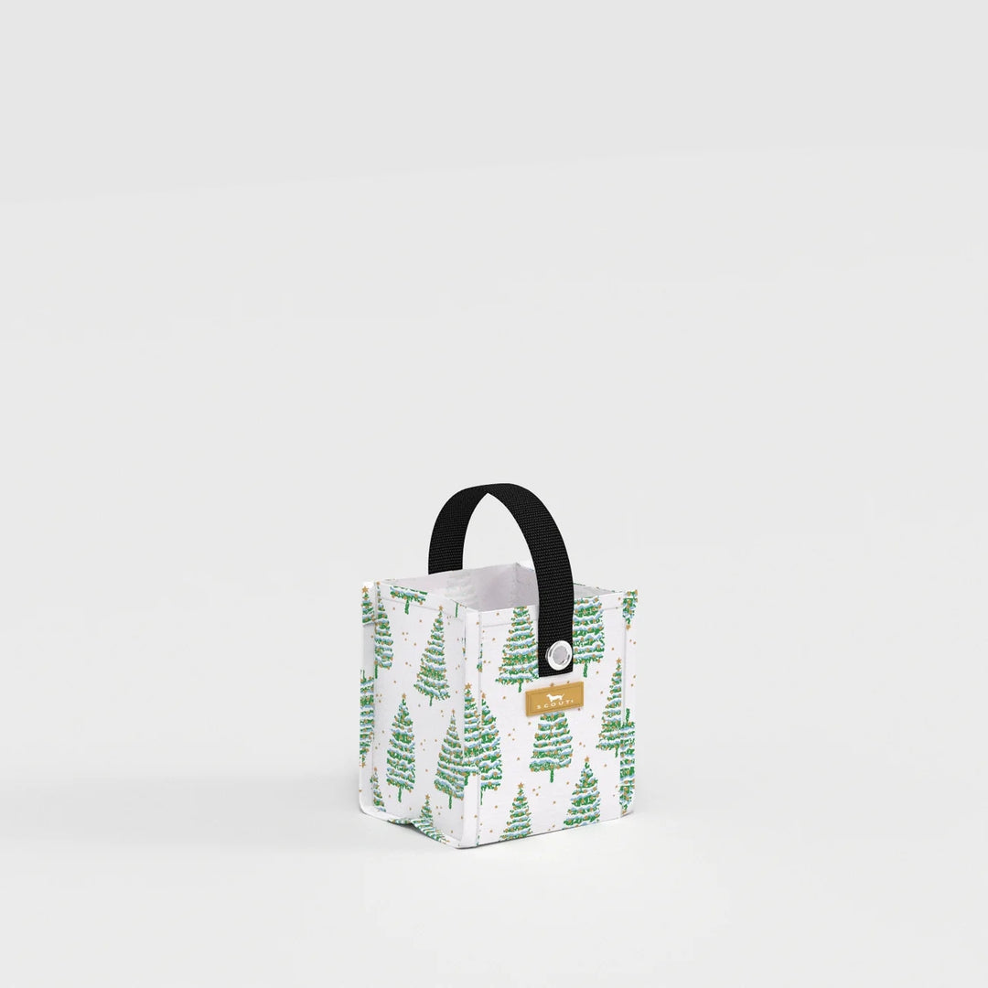 A small fabric storage basket with a white background, green pine tree pattern, and a black top handle. A small tan leather brand tag is attached on the front.
