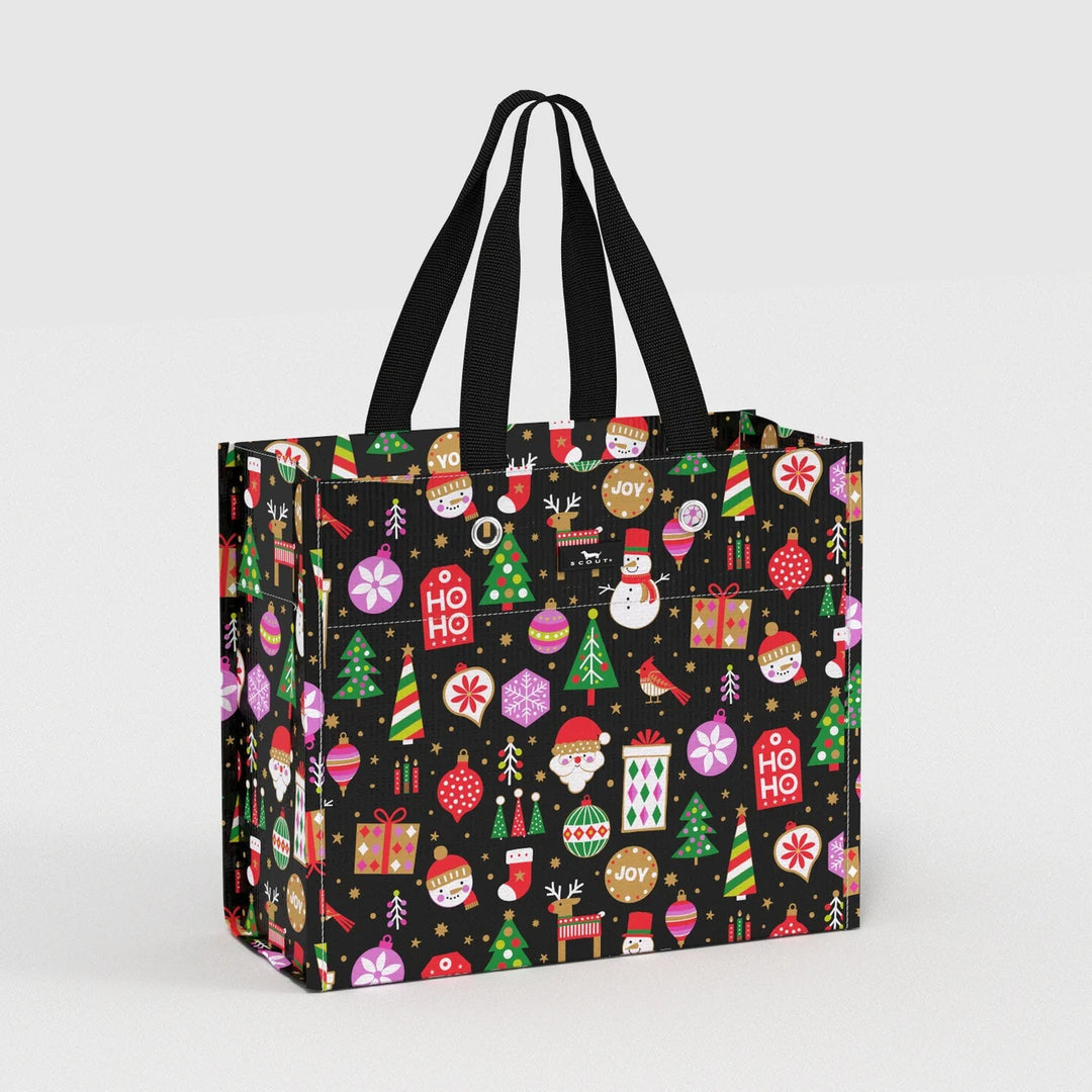 A reusable shopping tote bag with black handles, featuring a festive Christmas pattern on a black background with colorful ornaments, trees, gifts, Santa Claus, and holiday motifs.
