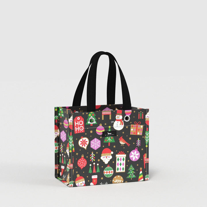 A black tote bag with black handles, decorated with a colorful Christmas pattern featuring ornaments, Santa Claus, snowman, gifts, and trees, shown on a light gray background.