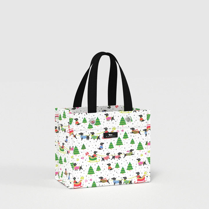A white canvas tote bag with black handles, featuring a festive Christmas dog print with Santa, sleighs, and Christmas trees, shown on a light gray background.