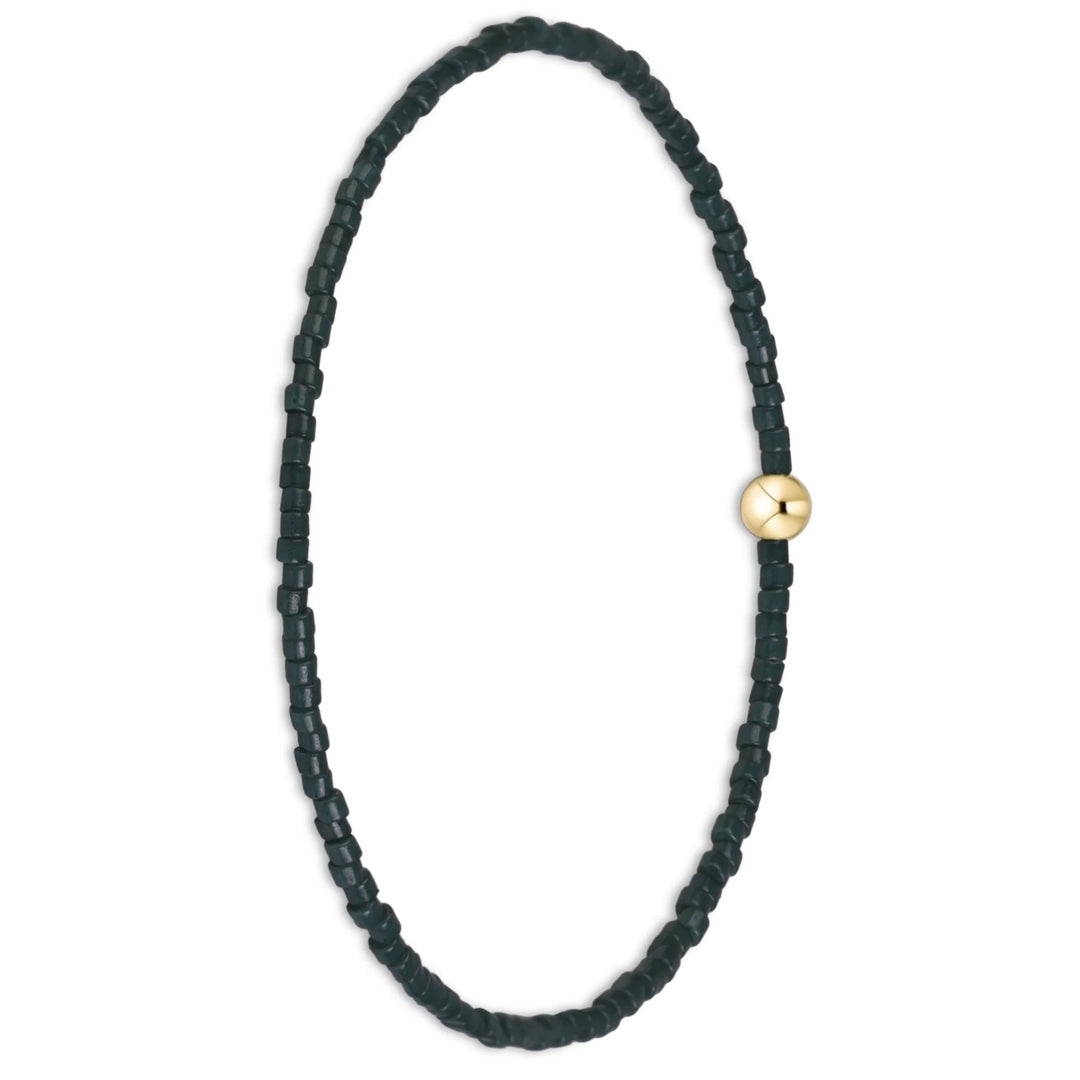 A beaded stretch bracelet featuring dark green faceted beads and a single gold-toned round accent bead, displayed on a clean white background.