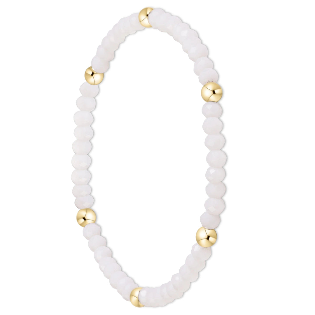 A beaded stretch bracelet featuring faceted white beads and polished gold spacer beads, displayed on a clean white background.