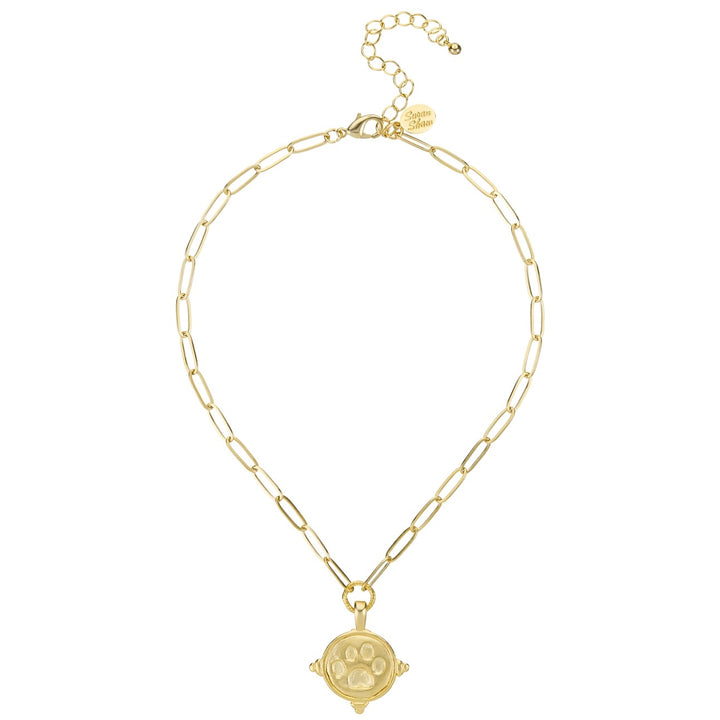 A gold paperclip chain necklace with a circular pendant featuring a paw print design, displayed on a clean white background.