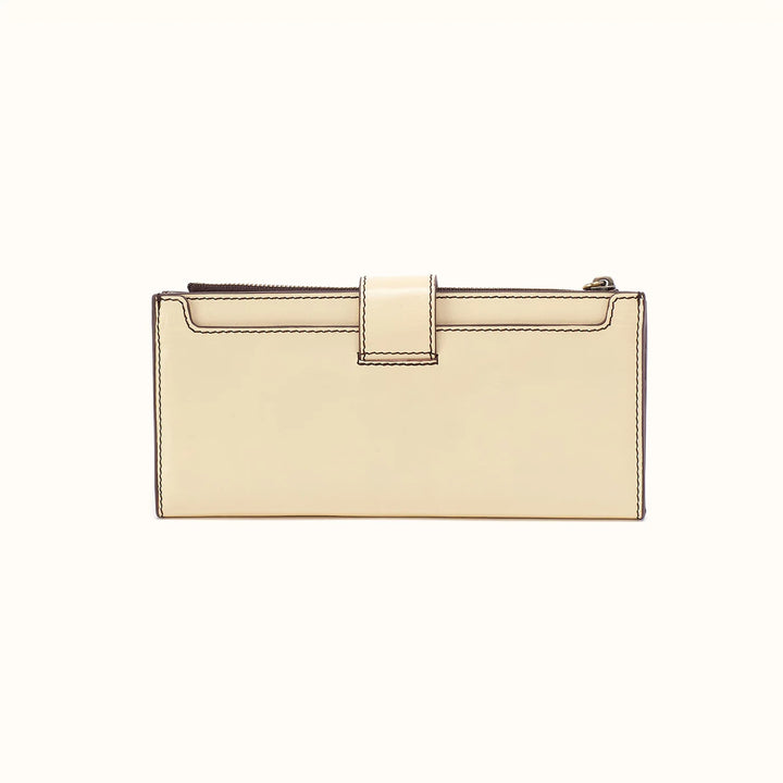 A cream-colored leather clutch wallet with a top zipper and a central tab closure, shown against a plain off-white background.