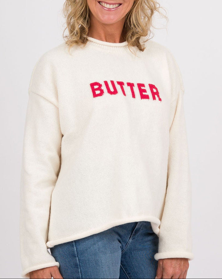 A woman modeling a cream-colored sweatshirt with &