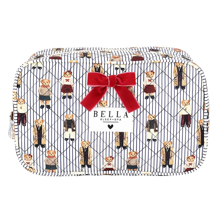 A zippered cosmetic pouch featuring a navy and white pinstripe background with a repeating pattern of teddy bears in school uniforms, accented by a large red velvet bow on the front and a white brand label that reads &