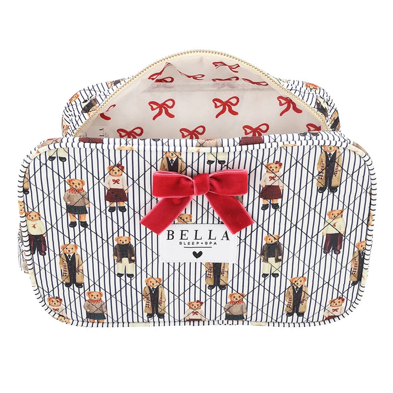 A zippered cosmetic bag with a navy and white diagonal stripe pattern, decorated with illustrations of teddy bears in suits and a large red velvet bow on the front. The interior is lined with a cream fabric featuring a red bow pattern.