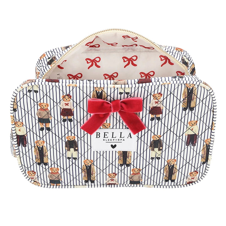 A zippered cosmetic bag with a navy and white diagonal stripe pattern, decorated with illustrations of teddy bears in suits and a large red velvet bow on the front. The interior is lined with a cream fabric featuring a red bow pattern.