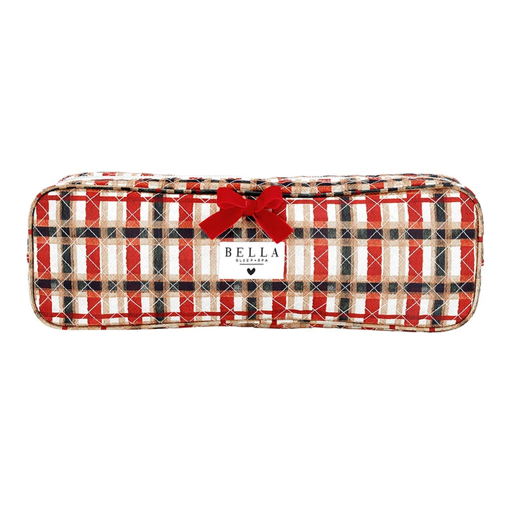 A long, padded pencil case with a red, beige, and black plaid pattern, featuring a red velvet bow on top and a white label that reads &