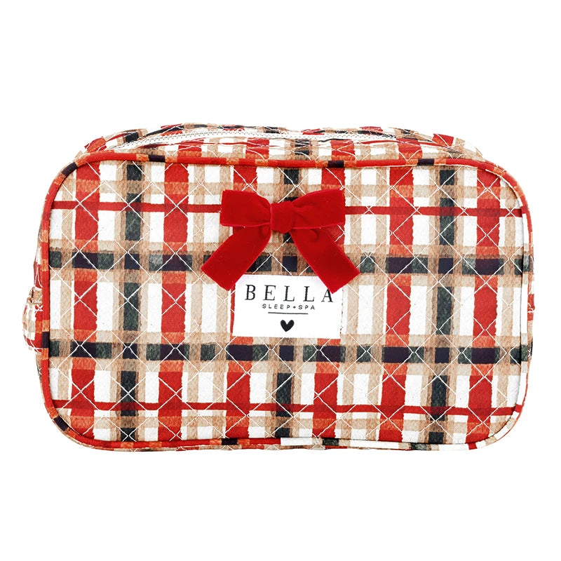 A red, beige, and black plaid zippered cosmetic bag with a red bow and a white Bella Sleep Spa label on the front, set against a plain white background.