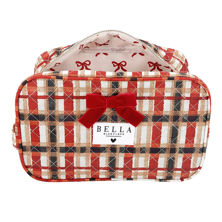 A red, beige, and black plaid cosmetic bag with a red velvet bow on the front and a white brand label that reads &