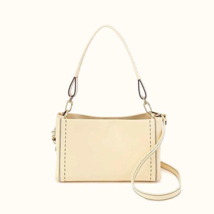 A cream-colored faux leather shoulder bag with a top handle and a detachable shoulder strap, displayed on a solid off-white background.