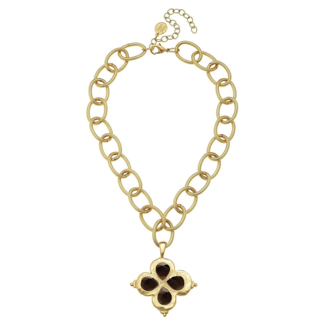 A gold-tone chain necklace with a four-petal clover pendant featuring dark brown inlays, displayed on a clean white background.