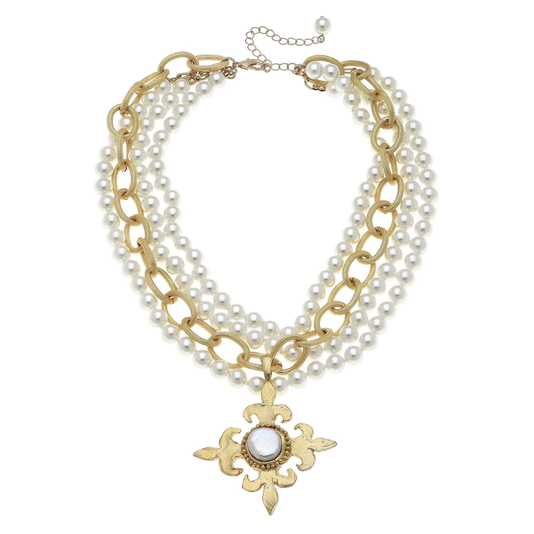 Multi-layered necklace with pearls and gold chain with gold fleur cross on a white background