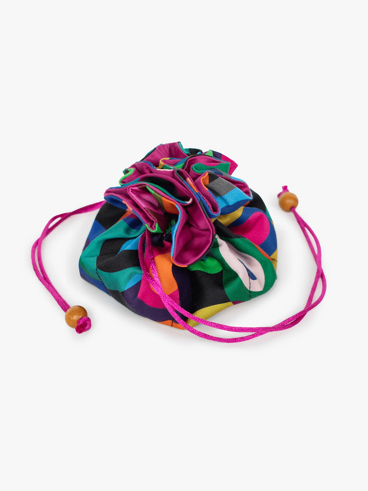 A small drawstring pouch with a vibrant multicolor abstract pattern, featuring bright pink drawstrings with wooden beads, set against a plain light gray background.