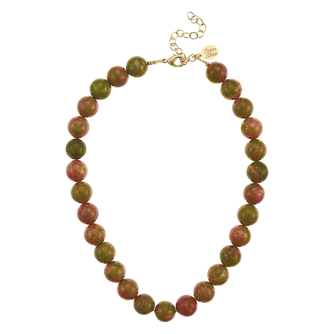 Necklace with green and red beads on a white background
